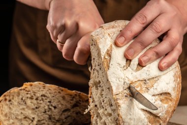 Taze pişmiş ekmek. Kadın eli ekmeği tutuyor. Yemek tarifi geçmişi. Kapat..