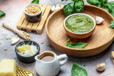 İçinde fesleğen, zeytinyağı, parmesan, sarımsak, çam fıstığı olan pesto sosu. afiş, menü, metin için tarif yeri, üst görünüm.