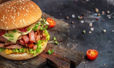 Çedarlı sığır burger, marul ve sosla ahşap bir tahtada, Hamburger. Fast food konsepti.