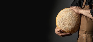 cheesemaker mele hands holding wheel hard cheese,