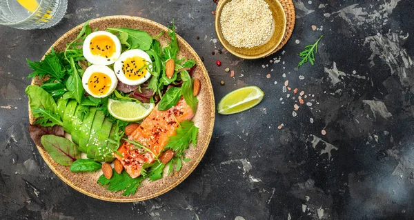 stock image Keto bowl salmon salad with greens, eggs and avocado. Ketogenic diet breakfast lunch. Top view.