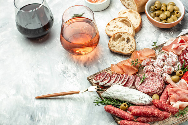Appetizers with differents antipasti, snacks and wine. Meat antipasto platter. Sausage, ham, tapas, olives. banner, menu, recipe place for text top view.