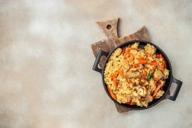 Uzbek pilaf in cast-iron pan. banner, menu, recipe place for text, top view.