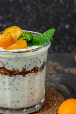 Chia pudding parfait, layered with kumquat and granola. breakfast. Healthy food concept. place for text.