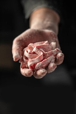 men hands holding sliced pastry for pasta on a dark background. home cooking concept.