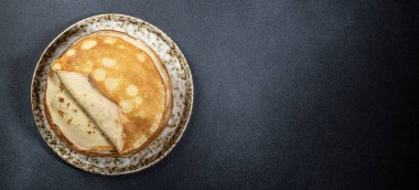 Krepler tabakta. Kahvaltıda ya da tatlıda ev yapımı taze krep. Uzun afiş biçimi. en üstteki görünüm,