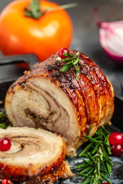 roast pork roulade Porchetta, delicious pork with cranberry berries on a dark background. Restaurant menu, dieting, cookbook recipe top view.