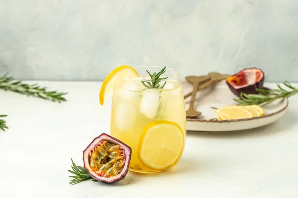 stock image glass of Iced passion fruit soda with lemon and passion fruit half slice on a light background, refreshing drink or beverage with ice, place for text,