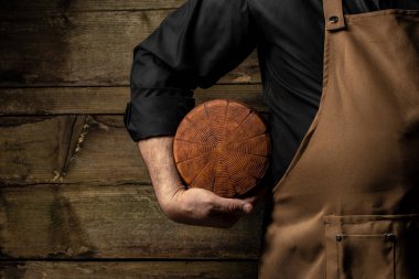 cheesemaker mele hands holding wheel hard cheese,