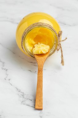 ghee oil. Ghee or clarified butter in jar on a light background. banner, menu, recipe place for text.