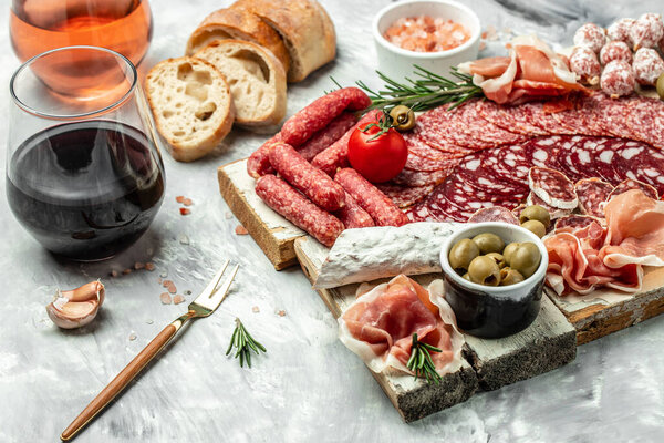 delicious salami, pieces of sliced prosciutto crudo, sausage and wine. Meat platter. Mixed delicatessen of meat snacks. place for text, top view.