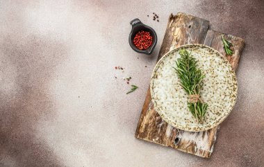 Boş ahşap mermi. Mutfak tahtası masada, çimento arka planda baharatlar ve otlar var. Yemek pişirme geçmişi. Uzun afiş biçimi. en üstteki görünüm.