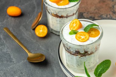 Chia pudding parfait, layered with kumquat and granola. breakfast. Healthy food concept. place for text.