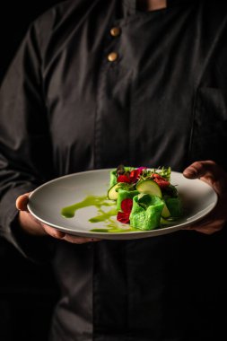 Adam elinde İtalyan ravioli makarnasıyla ıspanak ve ricotta tutuyor. dikey görüntü. Üst Manzara. metin için yer.