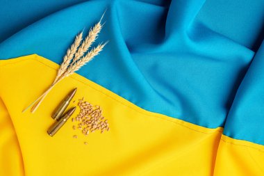 Ukrayna bayrağı arkaplanında gerçek mühimmat. Savaşı durdurun. Gıda tedarik krizi ve küresel gıda kıtlığı kavramı. metin için yer, üst görünüm.