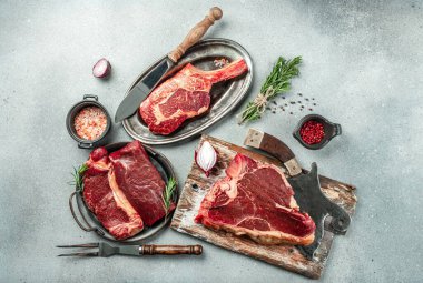 Çiğ Black Angus Prime bifteği T-bone, tomahawk, New York bifteği çeşitleri. Çiğ mermer sığır filetosu bifteği koyun. metin için yer, üst görünüm.