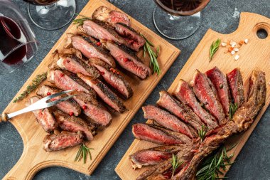 Dilimlenmiş ızgara biftek ahşap bir tahta üzerinde Striploin biftek, Restoran menüsü, diyet, yemek tarifi üst görünümü,