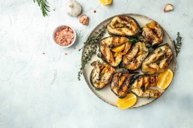 Limonlu ve baharatlı ızgara balık bifteği, arka planda hafif bir menü, diyet, yemek kitabı tarifi üst görünümü.,