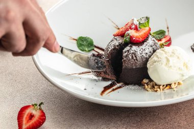 Çilekli çikolatalı lav keki. Sıvı dolgulu geleneksel Fransız çikolatalı keki.,