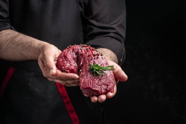 Şefin elleri biberiye ve baharatla fileto pişiriyor. Pişirmeye hazır taze biftek, restoran menüsü, diyet, yemek kitabı tarifi. metin için yer.