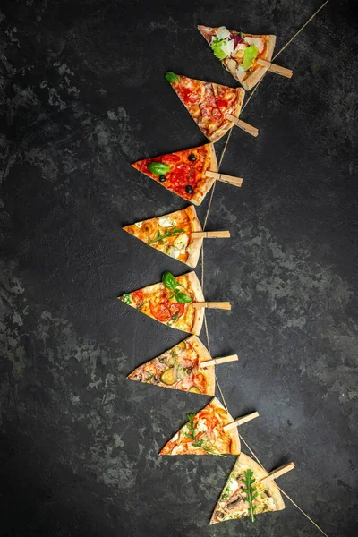 Различные Кусочки Пиццы Шнуре Прищепками Тёмном Фоне Вид Сверху — стоковое фото