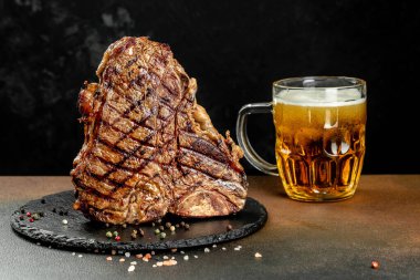 Izgara et ve bir kupa bira. T-bone ya da biftek bifteği. Restoran menüsü, yemek kitabı tarifi üst görünümü.