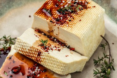 marinated tofu with herbs and spices. vegetarian tofu cubes on a dark background. banner, menu, recipe place for text, top view.