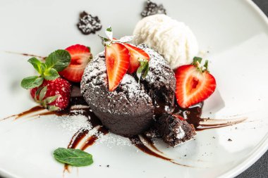 Taze çilekli çikolatalı lav keki, dondurma topu ve nane, yemek tarifi geçmişi. Kapat.,