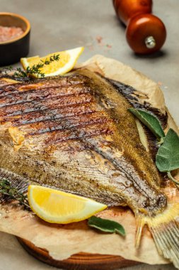 Baked Flounder Fish with herbs and lemon, Delicious balanced food concept, Restaurant menu, dieting, cookbook recipe top view,