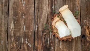 Fresh raw mushrooms, king oyster or eringi on a wooden background, banner, menu, recipe place for text, top view,