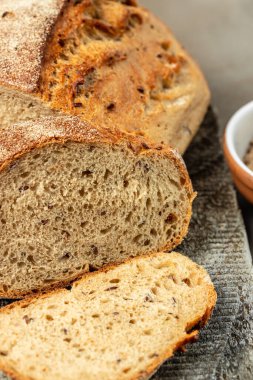Tohumlu taze ekmek, dilimlenmiş susam. dikey görüntü. Üst Manzara. metin için yer,