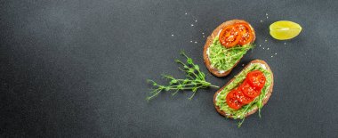 Kahvaltıda ya da öğle yemeğinde sağlıklı avokado tostları ve çavdar ekmeği. Vejetaryen yemeği. Vejetaryen menüsü. Uzun afiş biçimi. en üstteki görünüm.