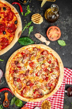 Pizza arkaplanını ayarla. Koyu arka planda çeşitli İtalyan pizzaları, Fast Food öğle yemeği, dikey görüntü. Üst Manzara. metin için yer,