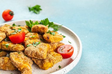 Mavi arka planda ev yapımı tavuk nuggetları, yemek tarifi geçmişi. Kapat.,