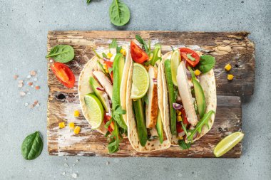 Izgara tavuklu taco, avokado, taze domates, limon. Tahta üzerinde Meksika dürümleri. afiş, menü, metin için tarif yeri, üst görünüm.