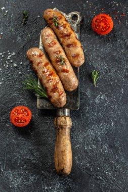 Biberiyeli ızgara sosis ve çatal. Baharatlı et sosisleri, dikey görüntü. metin için yer.