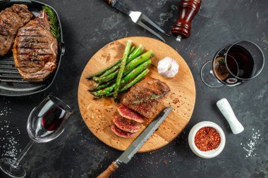 Biftek ve kırmızı şarap. Ahşap kesme tahtasında ızgara et. afiş, menü, metin için tarif yeri, üst görünüm.