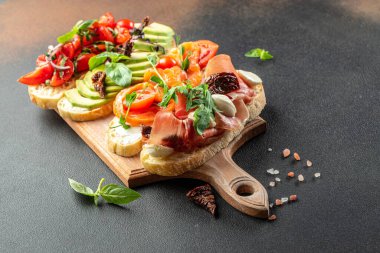 Tahta bir tahtada jambon, somon, domates ve avokado soslu bruschetta seti, pankart, menü, yazı için tarif yeri, üst görünüm.,