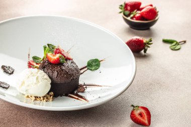 Taze çilekli çikolatalı lav keki, dondurma topu ve nane, yemek tarifi geçmişi. Kapat.,