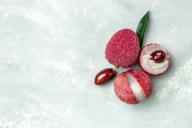 Hafif arka planda taze organik liçi meyvesi, uzun afiş formatında. en üstteki görünüm,