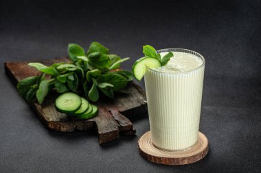 Ayran or Doogh is a popular refreshing yogurt on a dark background. Restaurant menu, dieting, cookbook recipe top view. clipart