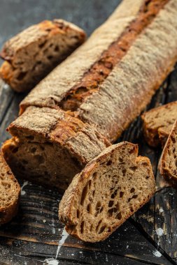 Ekmek ekmeği ya da tahtanın üzerinde ekmek rulosu. dikey görüntü. Üst Manzara. metin için yer.