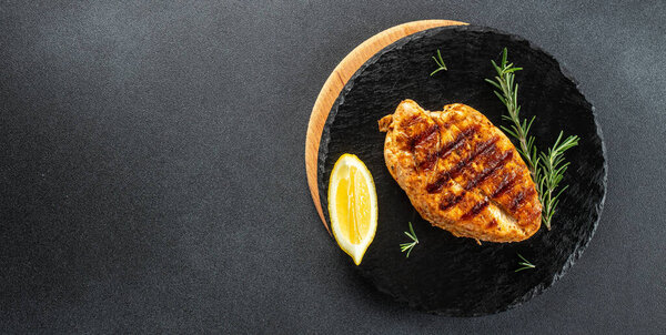 grilled chicken fillet on a dark background. Healthy fats, clean eating for weight loss. Long banner format. top view.