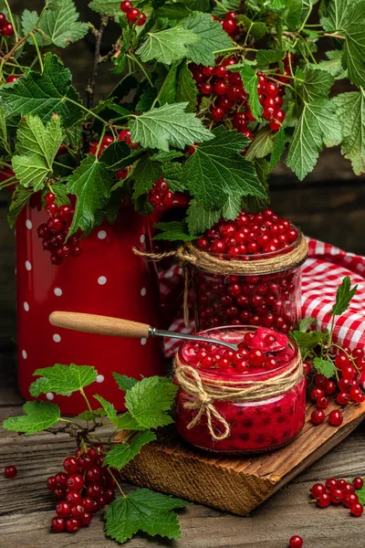 Homemade Red Currant Jam with fresh fruits on wooden table. vertical image. top view. place for text.