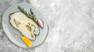Fillet of fresh sea white cod fish steak Anarhichas on plate. banner, menu, recipe place for text, top view.
