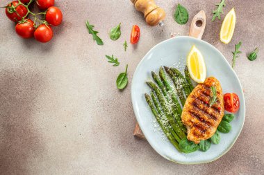 Sebzeli kuşkonmaz ve parmesanlı organik sağlıklı ürünlerle ızgara yapılmış sulu tavuk göğsü. Detoks ve temiz diyet konsepti. metin için yer, üst görünüm,