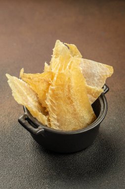 Bira için atıştırmalıklar, ahşap tabakta kurutulmuş balık karışımı. Koyu arkaplanda kurutulmuş balık sucuğu eti carpaccio. metin için yer, üst görünüm.