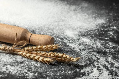 Buğday unu, tahıl ve kulaklar koyu arkaplanda. afiş, menü, metin için tarif yeri, üst görünüm.