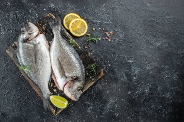 Tahtada pişmemiş Dorado balığı var. Sağlıklı ve dengeli beslenme kavramı. metin için yer, üst görünüm.