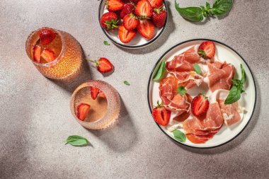 İberya jambonu, çilek ve gözlüklü gül şarabı. Restoran menüsü, diyet, yemek kitabı tarifi üst görünümü.